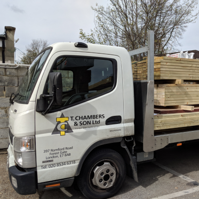 a flatbed lorry with chambers timber company logo delivering timber materials